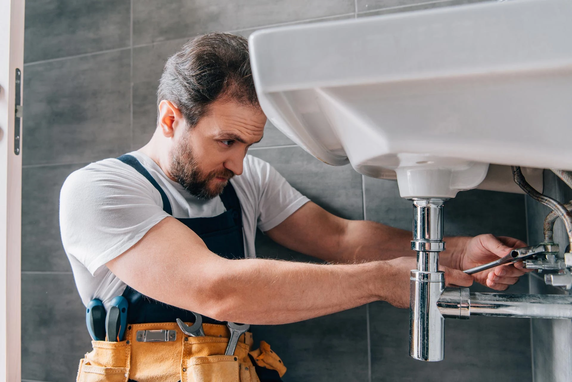 Plumber fixing bathroom sink in Richmond Hill