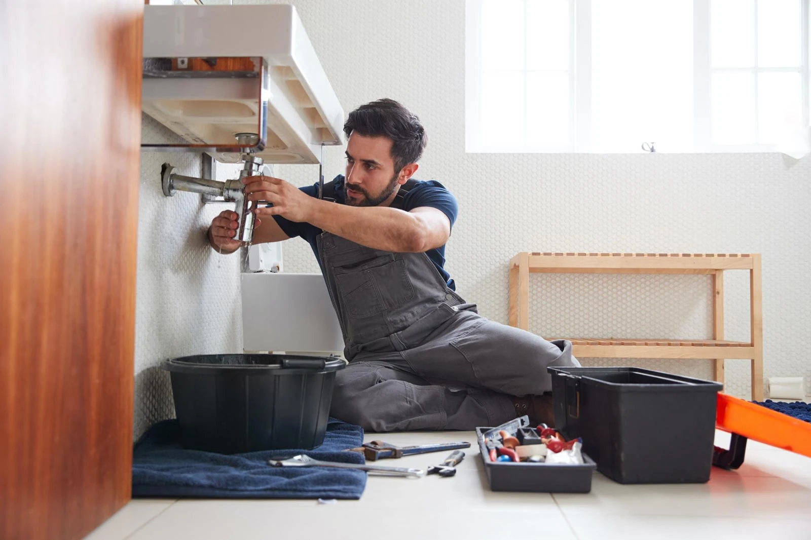 plumber fixing leak bathroom sink